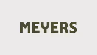 Bildet viser ordet "MEYERS" med dristige, mørkegrønne store bokstaver på en lysegrå bakgrunn.